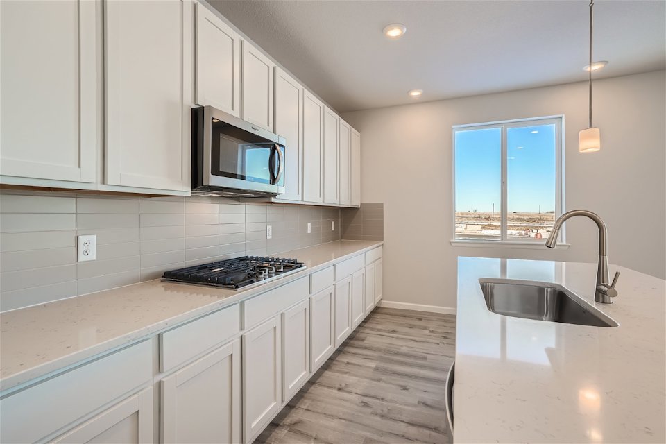 A kitchen with white cabinets.