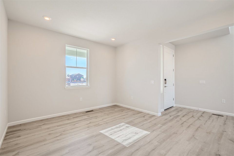 A room with a wood floor and a window.