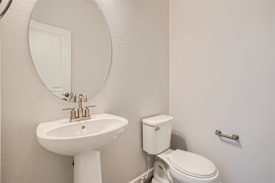 A bathroom with a round mirror.