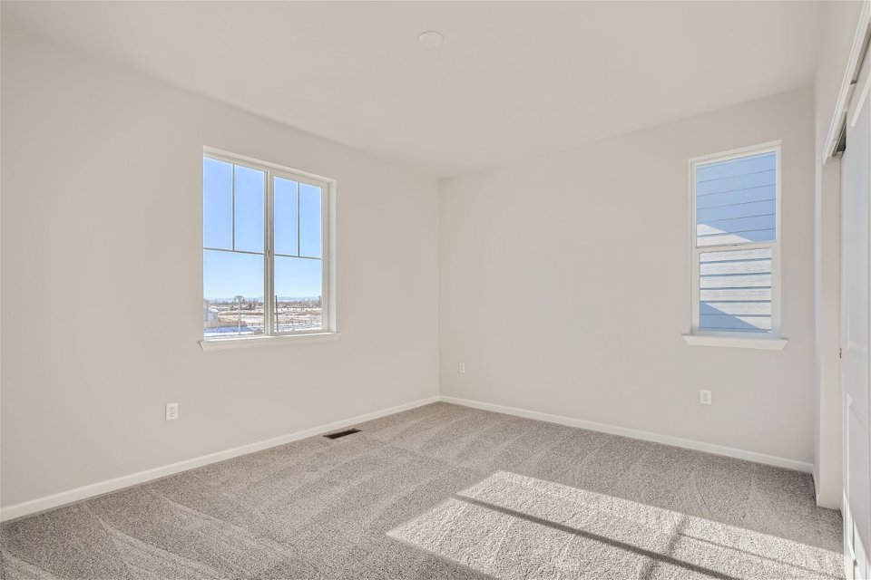 A room with a rug and a window.