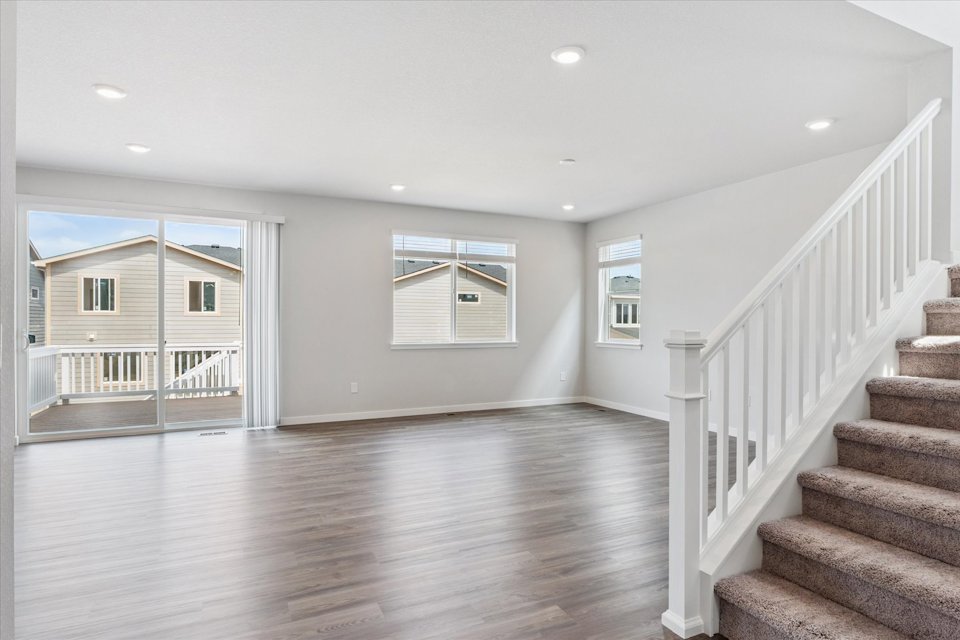 A large empty room with a wood floor and white walls.