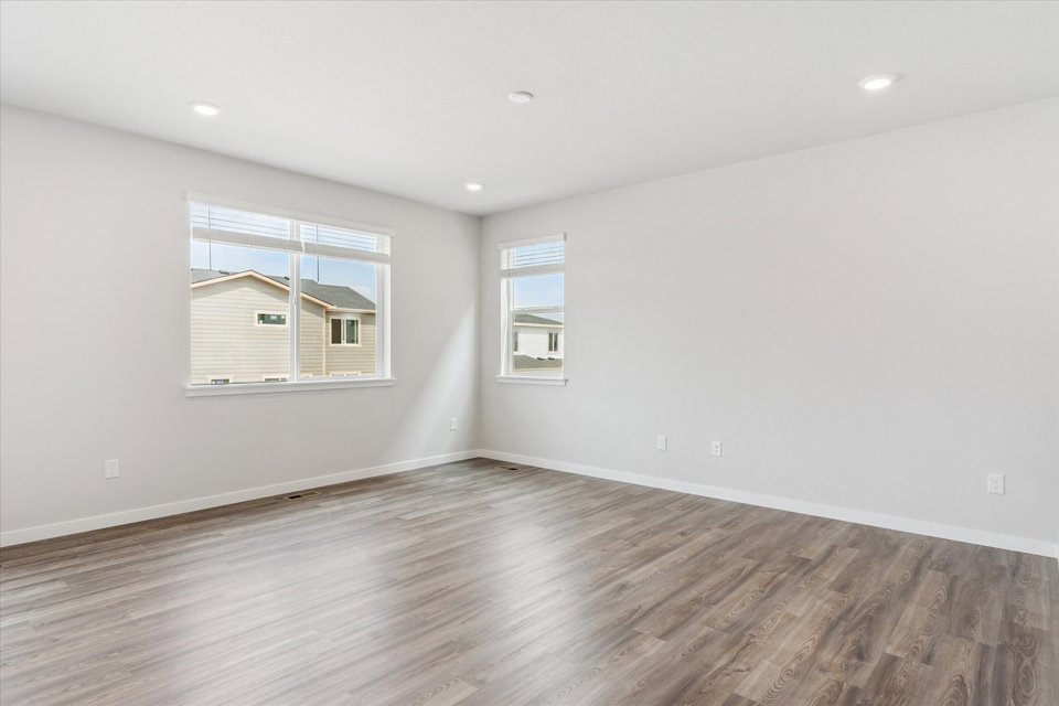 A room with a wood floor and windows.