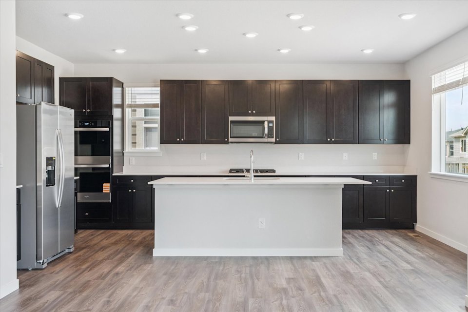 A kitchen with black cabinets.