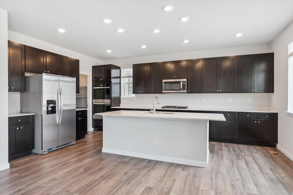 A kitchen with black cabinets.