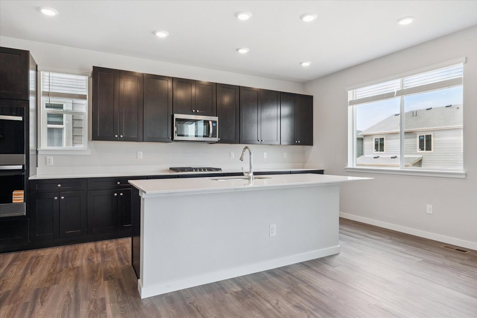 A kitchen with black cabinets.