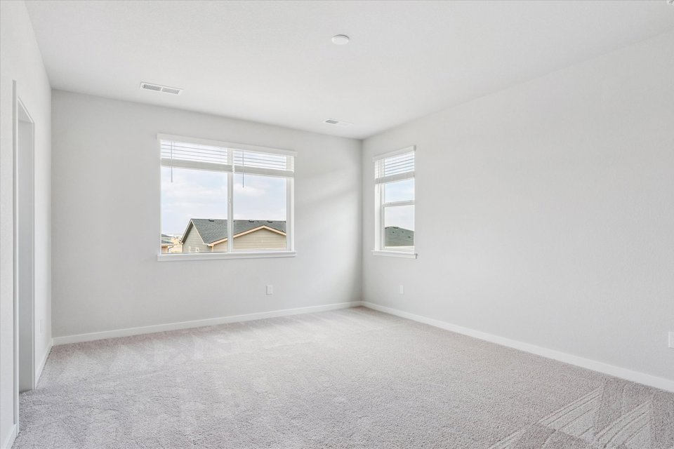 A room with a window and a white wall.