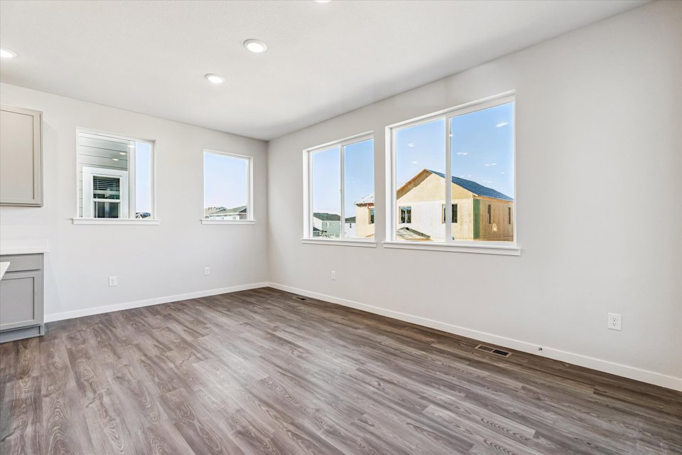A room with a wood floor and a window with a view of the ocean.