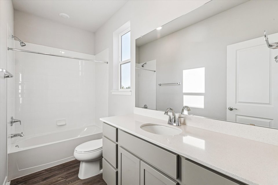 A bathroom with a tub sink and toilet.