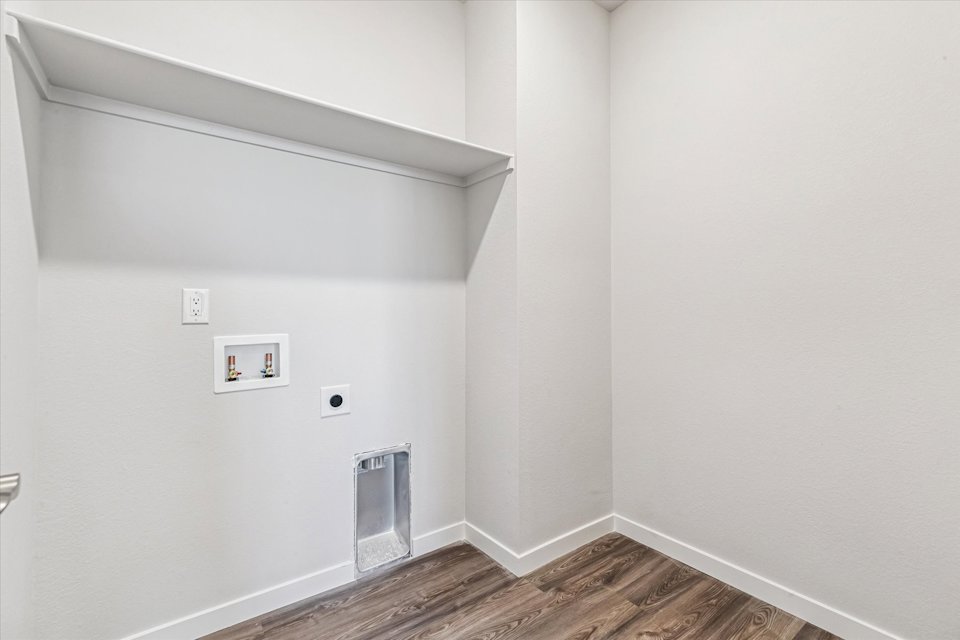 A white room with a wood floor.