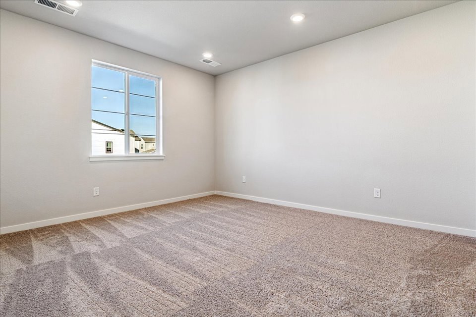 A room with a carpet and a window.