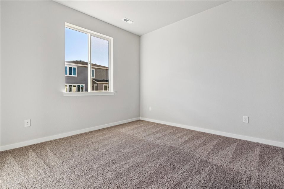 A room with a window and carpet.