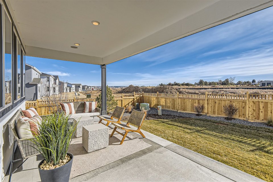 A patio with chairs and a table.