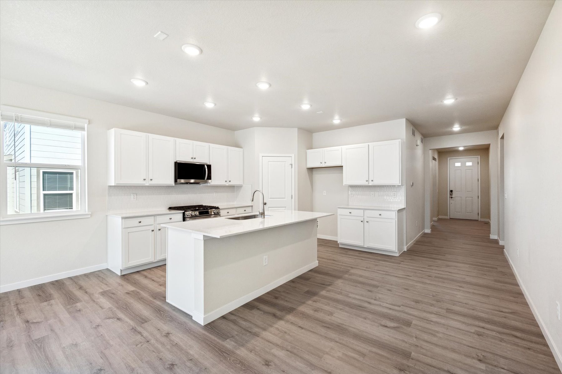 A kitchen with white cabinets.
