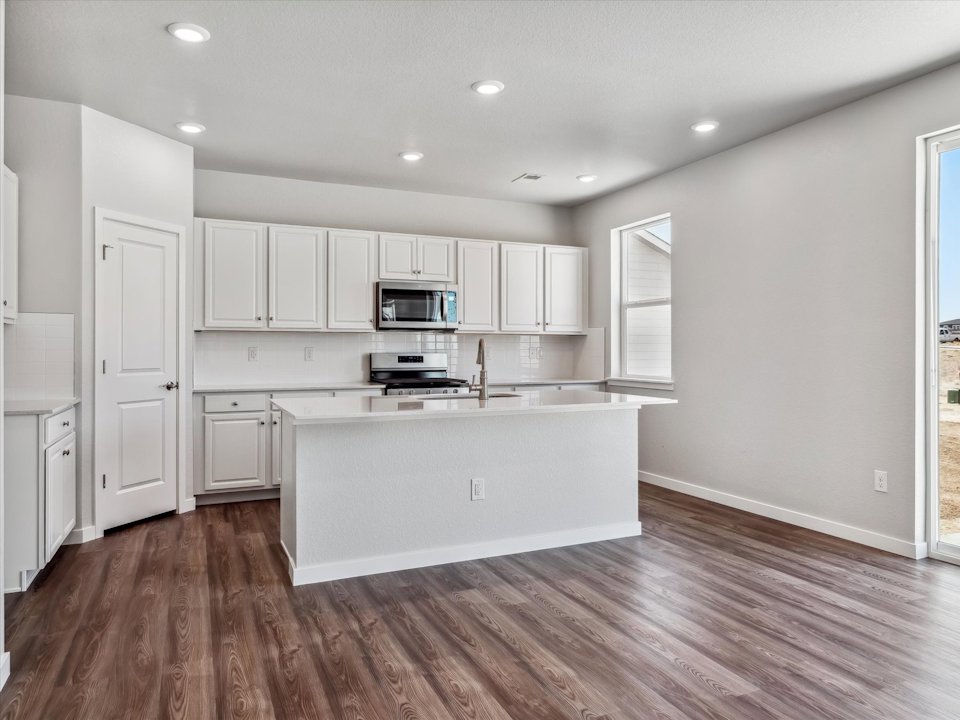 A kitchen with white cabinets.