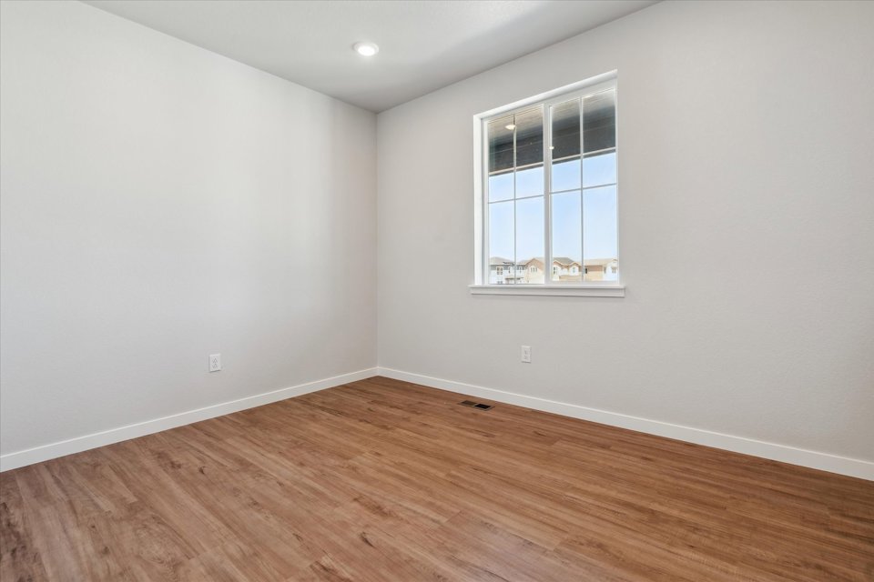 A room with a wood floor and a window.