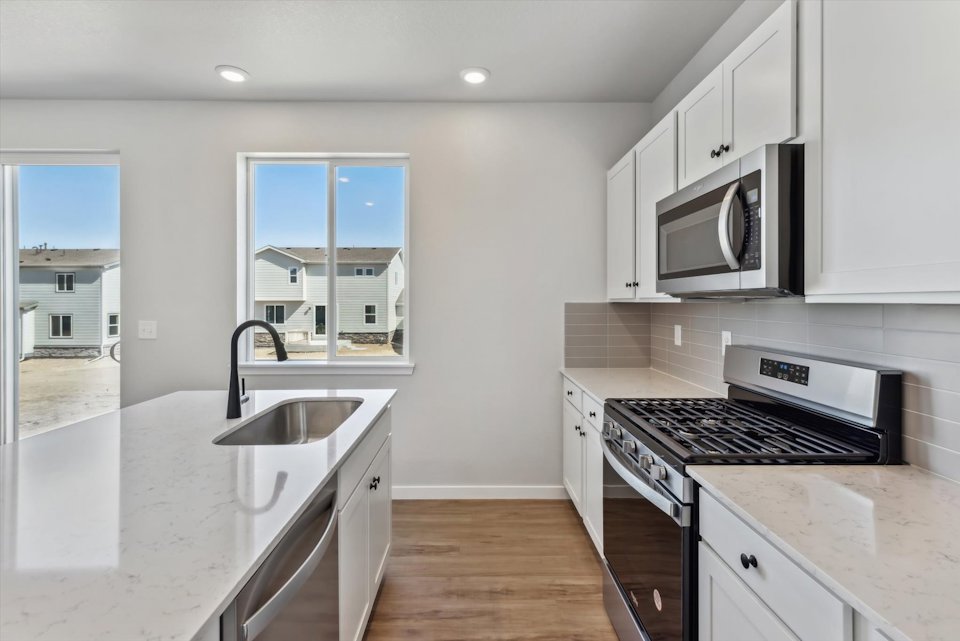 A kitchen with white cabinets.