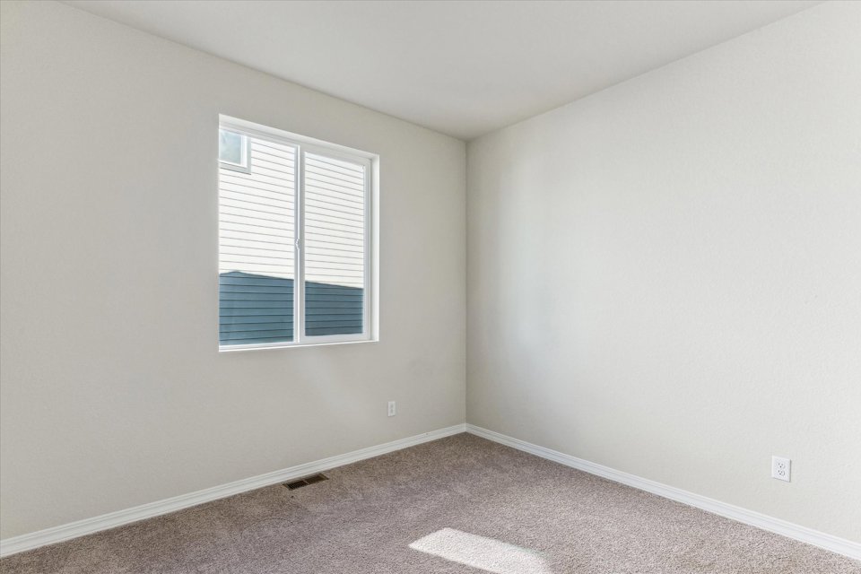 A room with a window and a carpet.