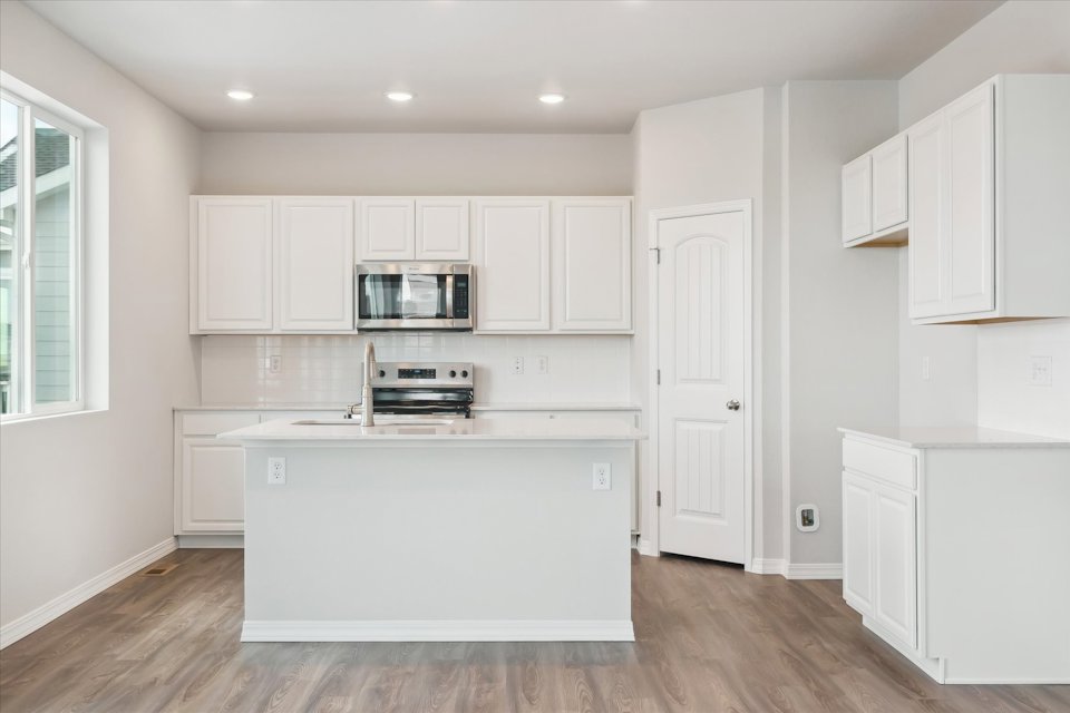 A kitchen with white cabinets.