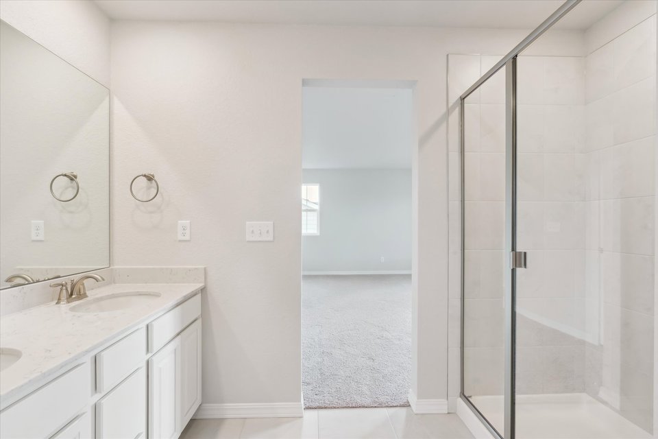A bathroom with a shower unit and sink.
