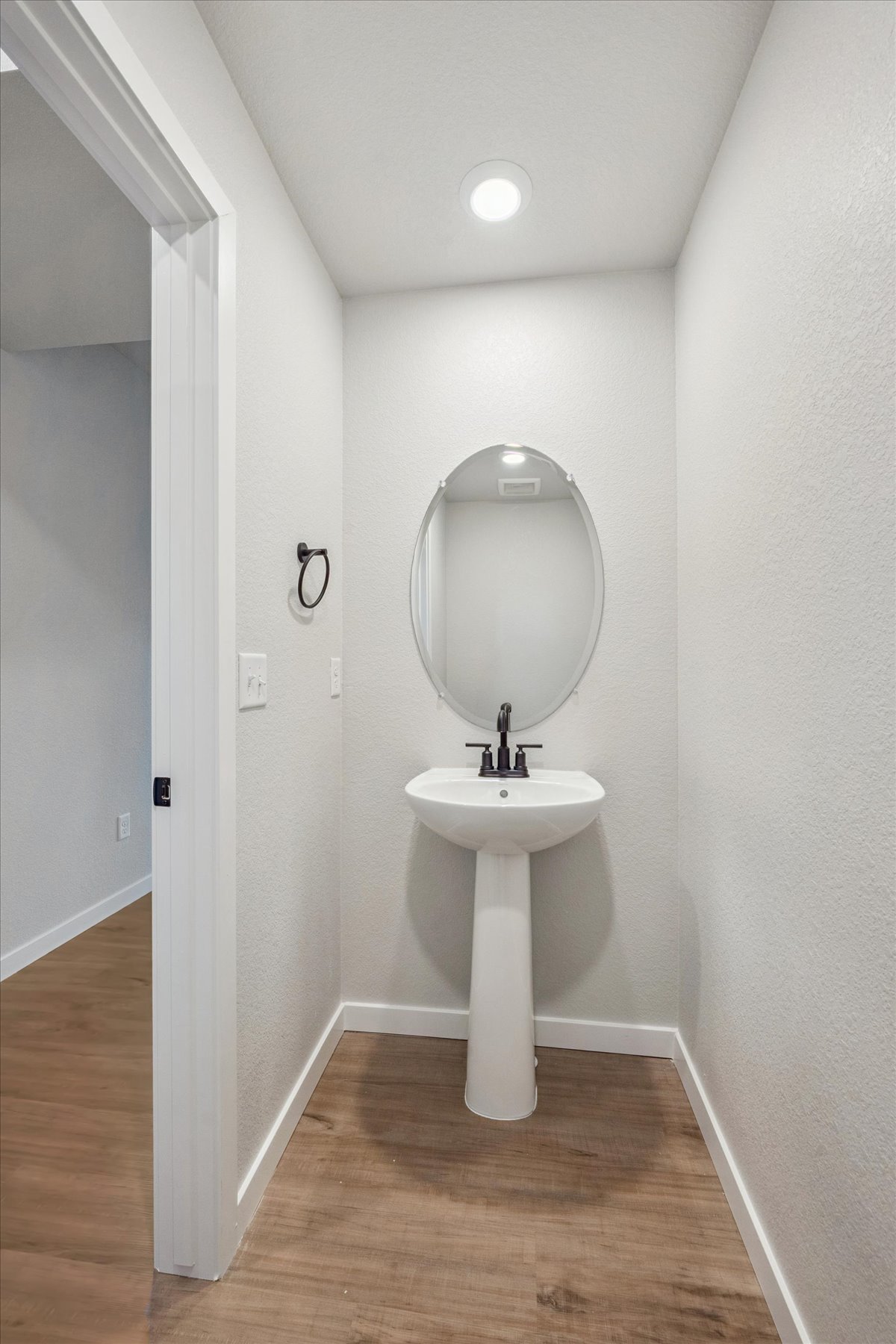 A bathroom with a round mirror.