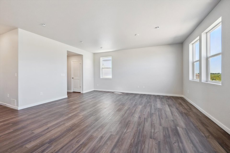 A room with a wood floor and windows.