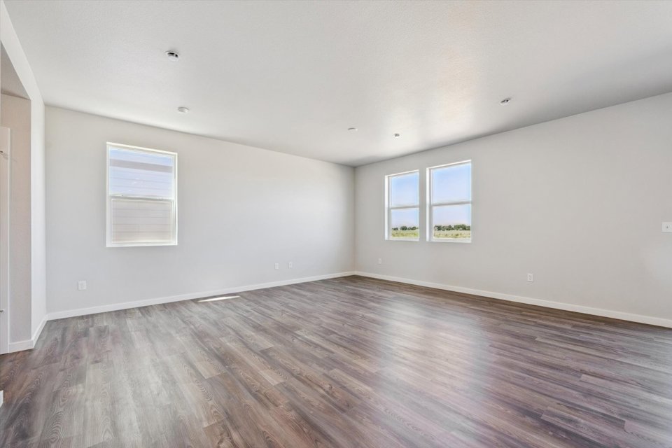 A room with a wood floor and windows.