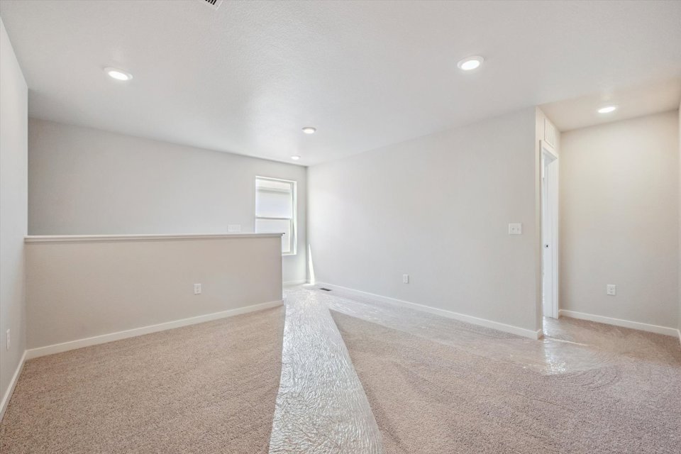 A room with a carpet and a white wall.