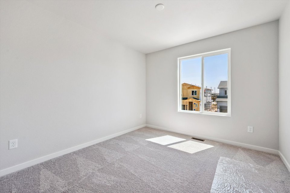 A room with a window and a rug.