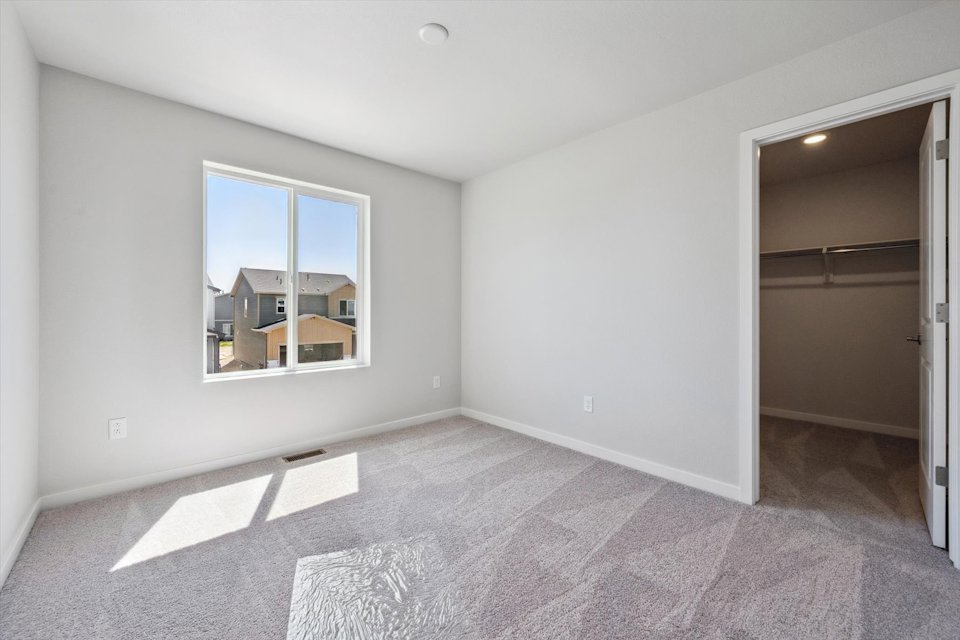 A room with a window and a rug.