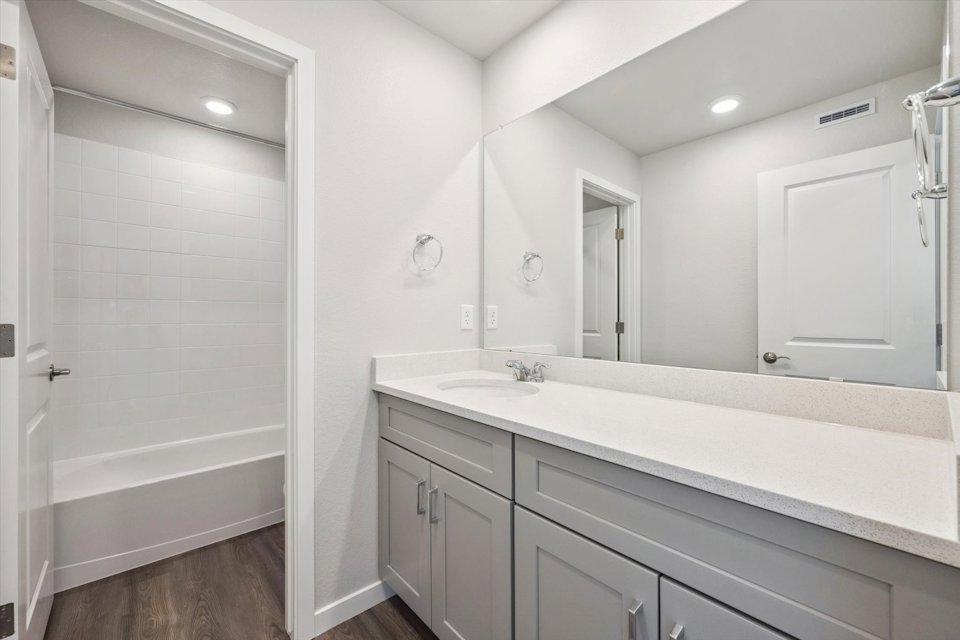 A bathroom with a tub sink and shower.