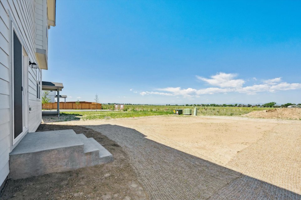 A road with grass and buildings on the side.