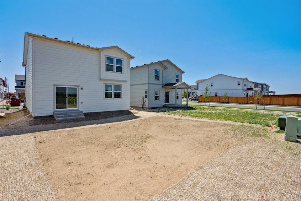 A dirt road leading to a house.