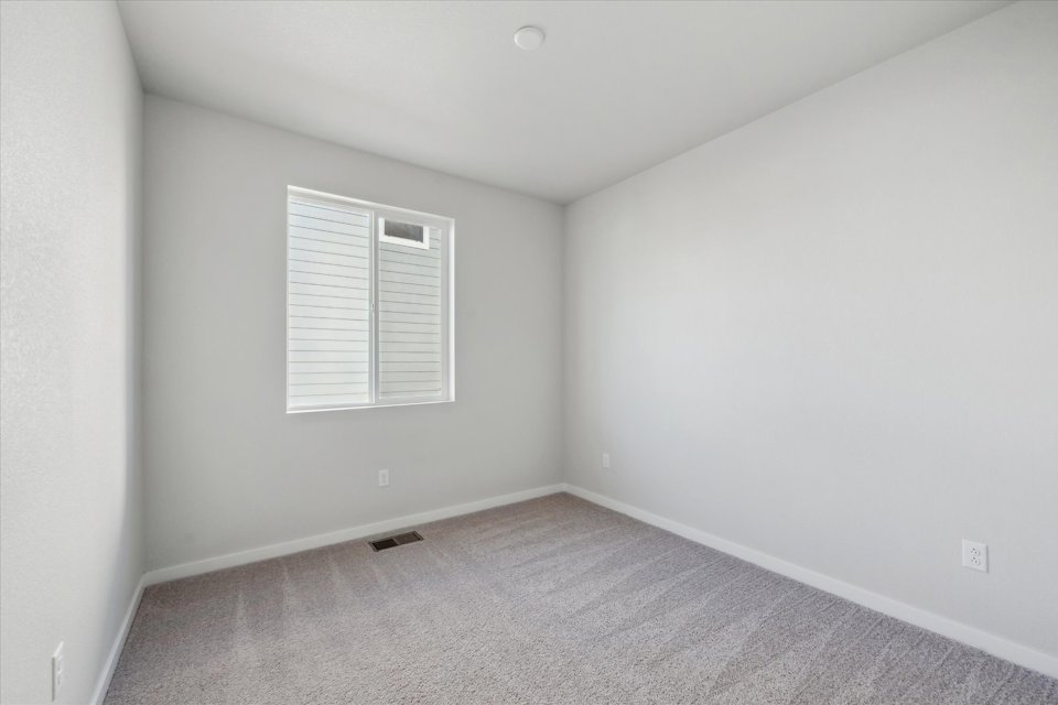 A room with a white wall and a window.