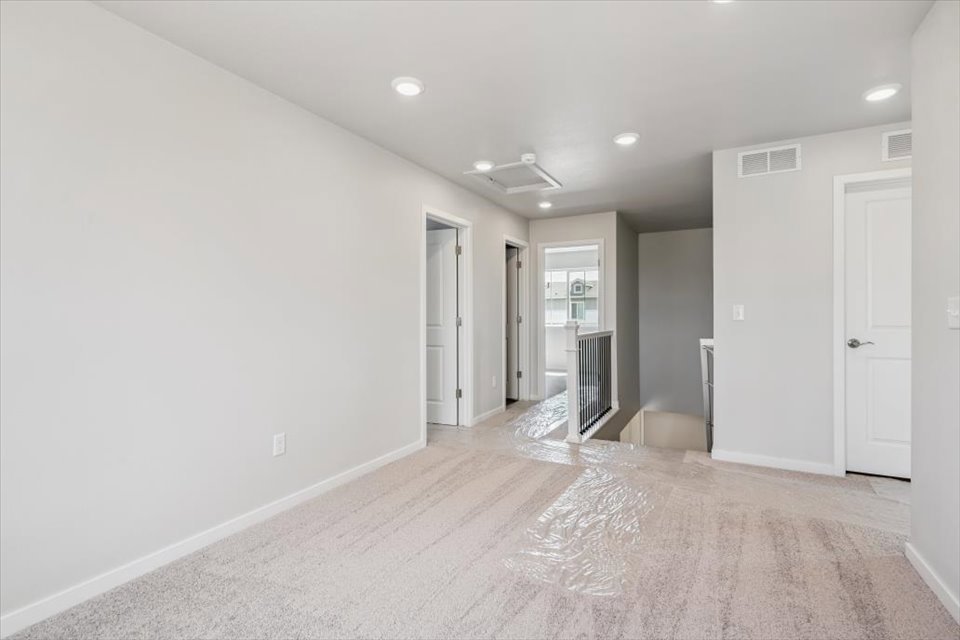 A long hallway with white doors.