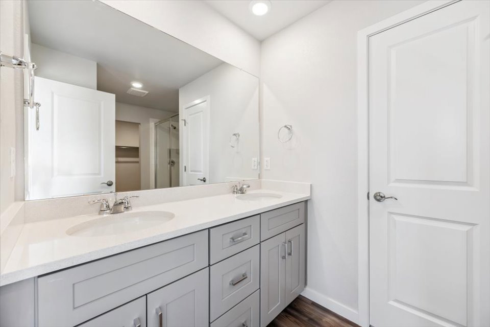 A bathroom with white cabinets.