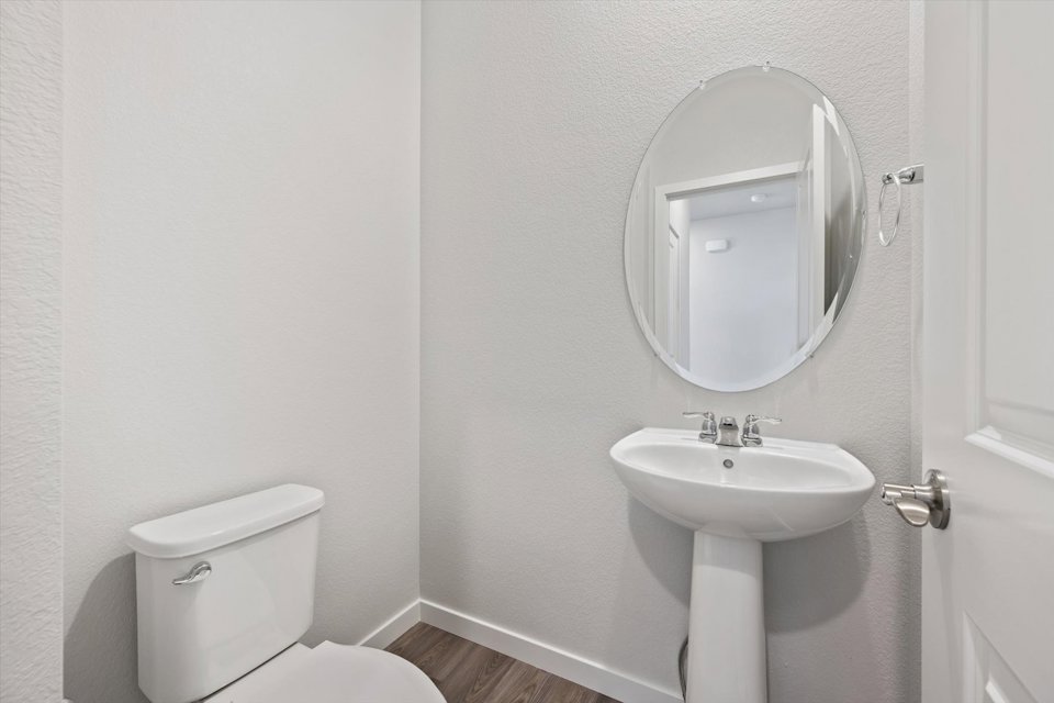 A bathroom with a round mirror.