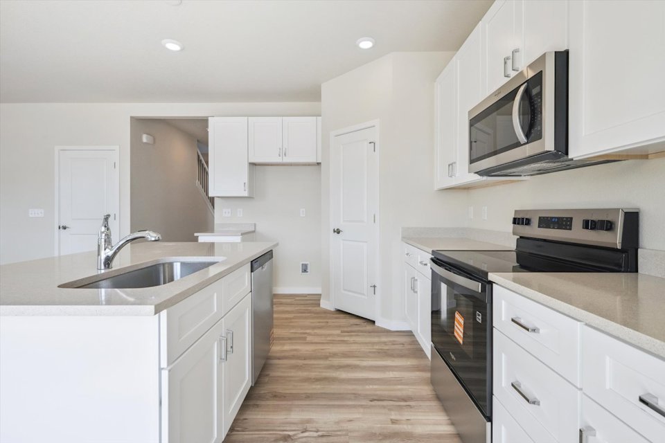 A kitchen with white cabinets.