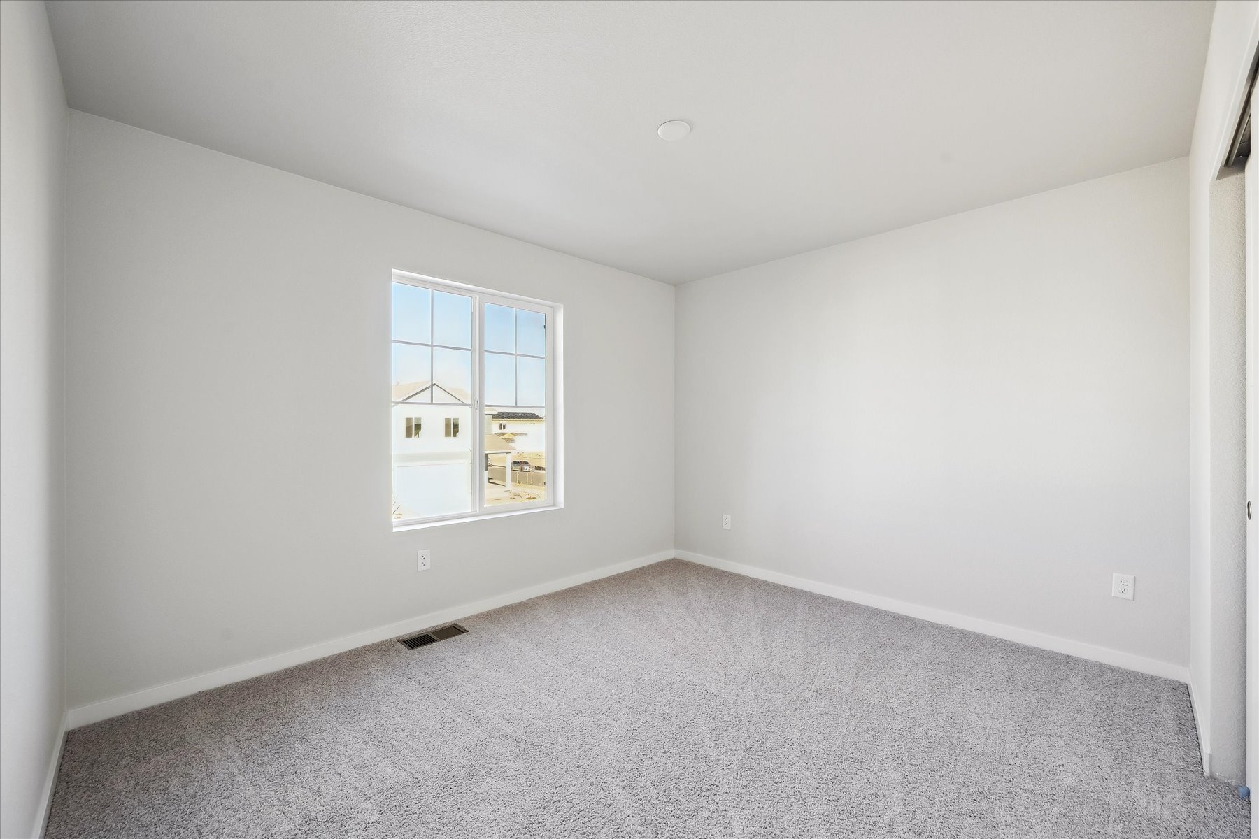 A room with a window and a carpet.