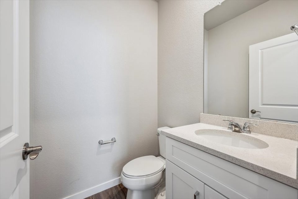 A bathroom with a sink toilet and mirror.