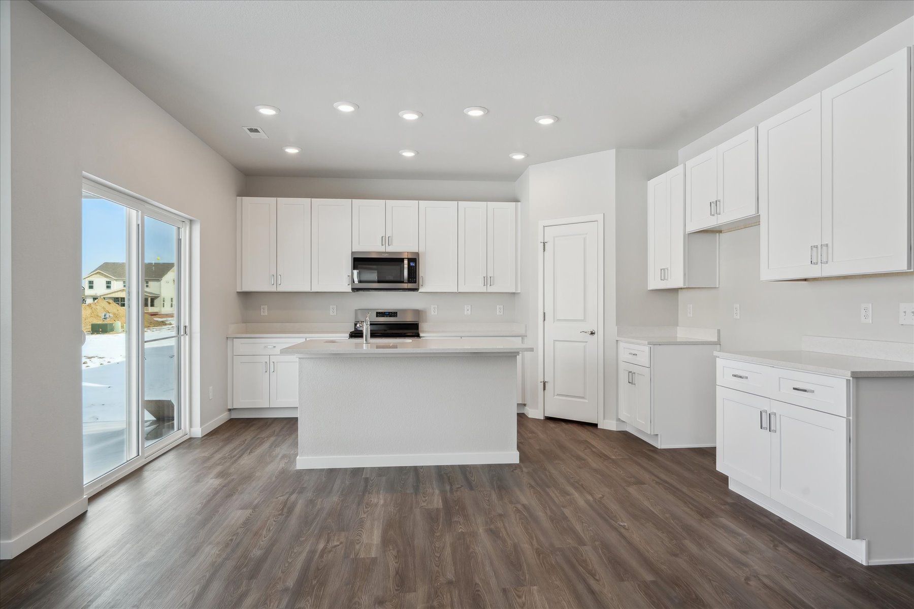 A kitchen with white cabinets.