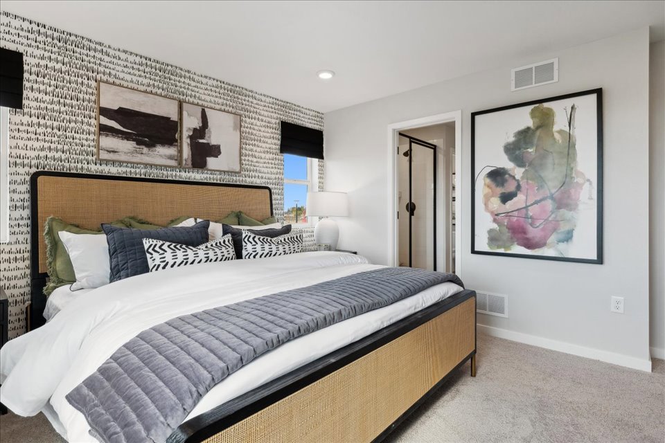 A bedroom with a bed and a painting on the wall.