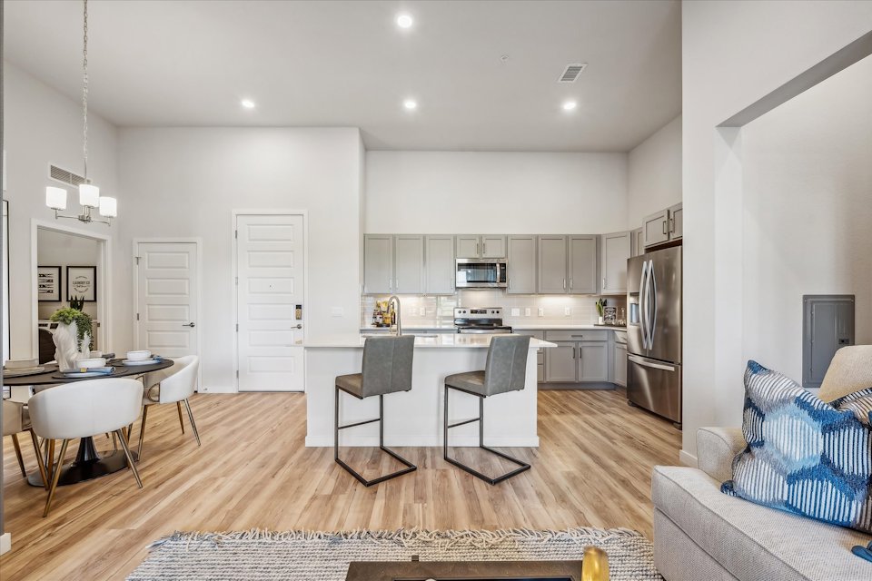 A kitchen with a dining table and chairs.