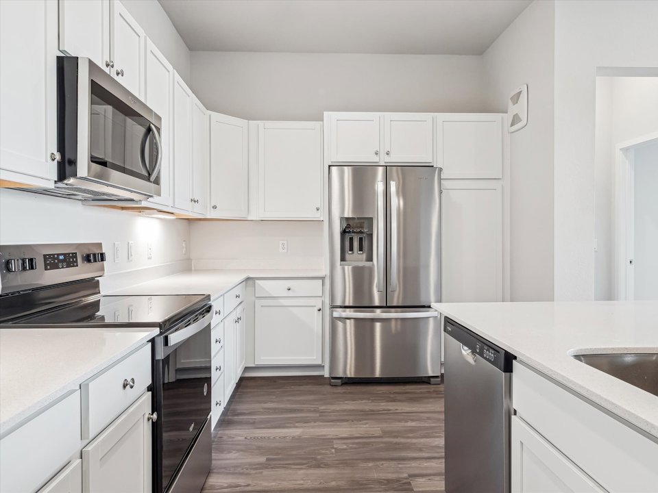 A kitchen with white cabinets.
