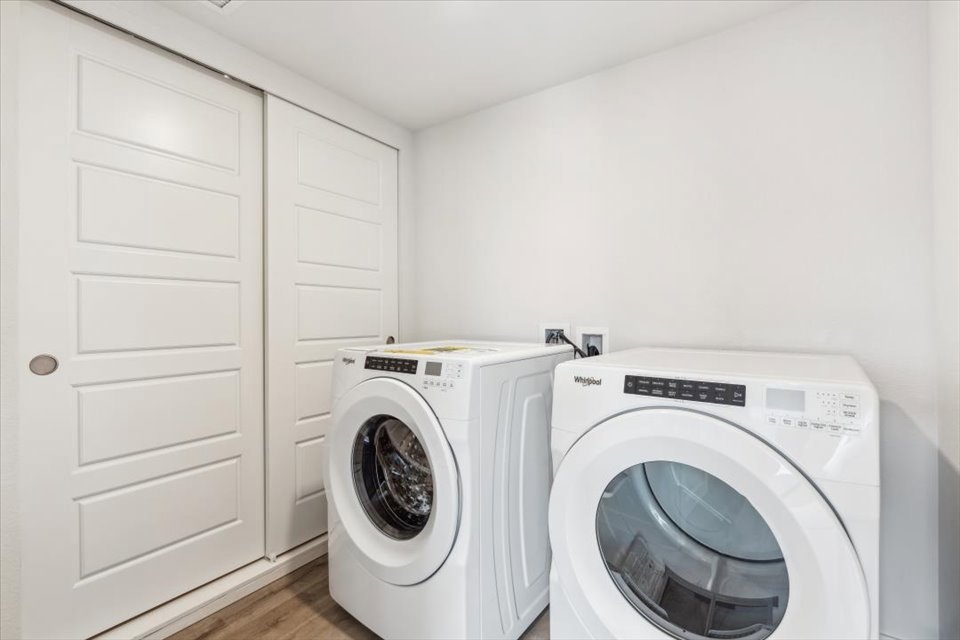 A white laundry room with a washing machine and a dryer.