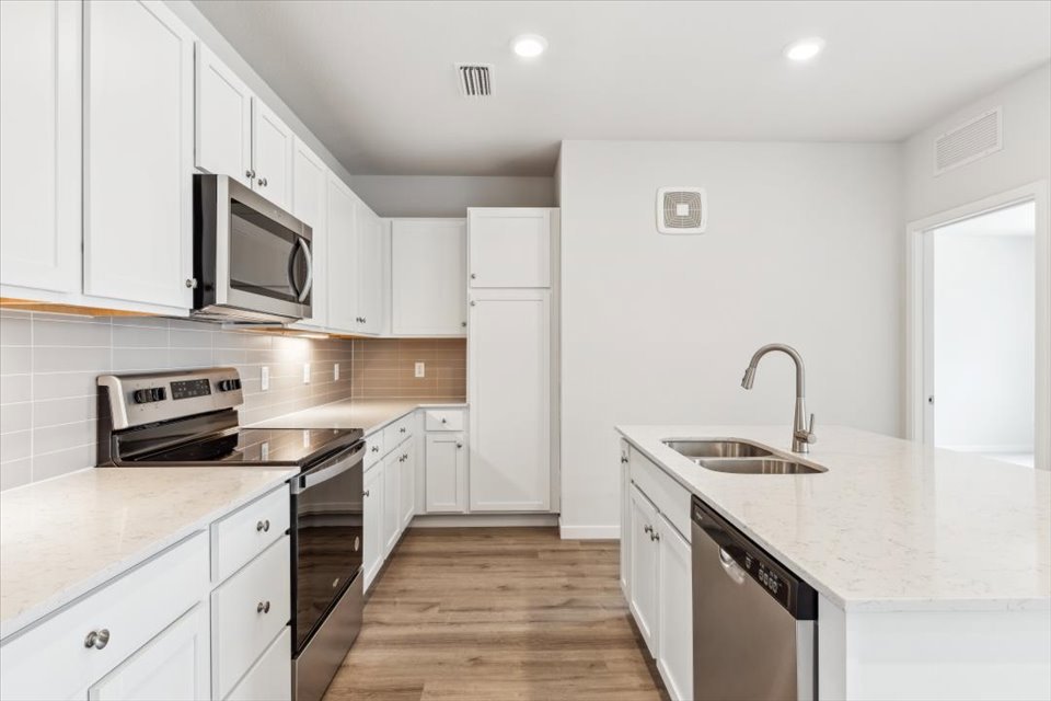 A kitchen with white cabinets.