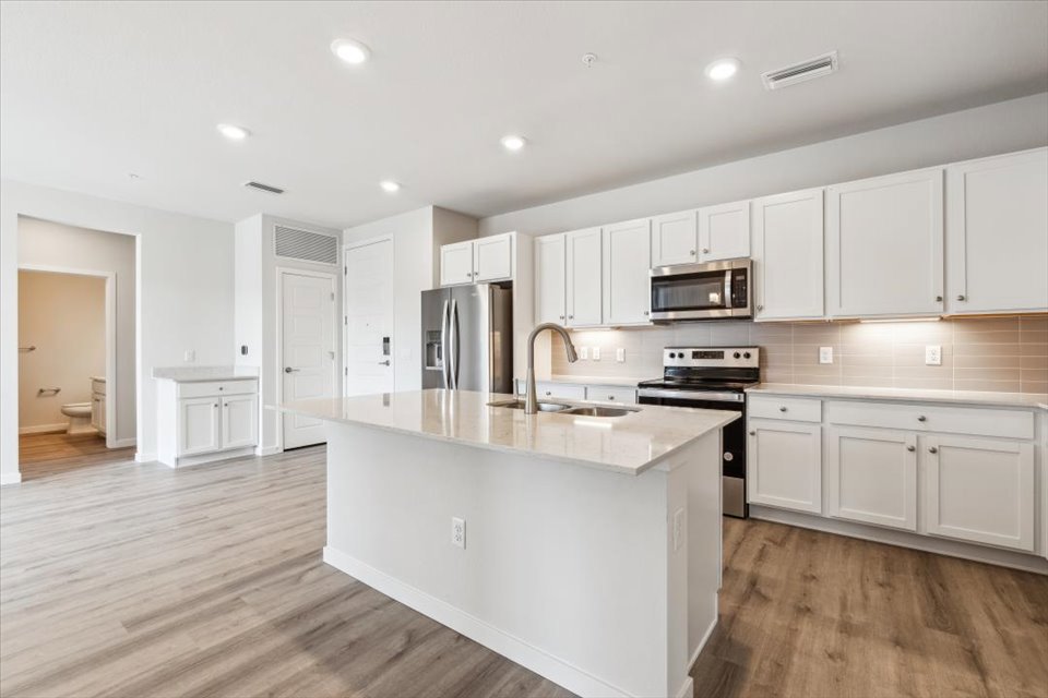 A kitchen with white cabinets.