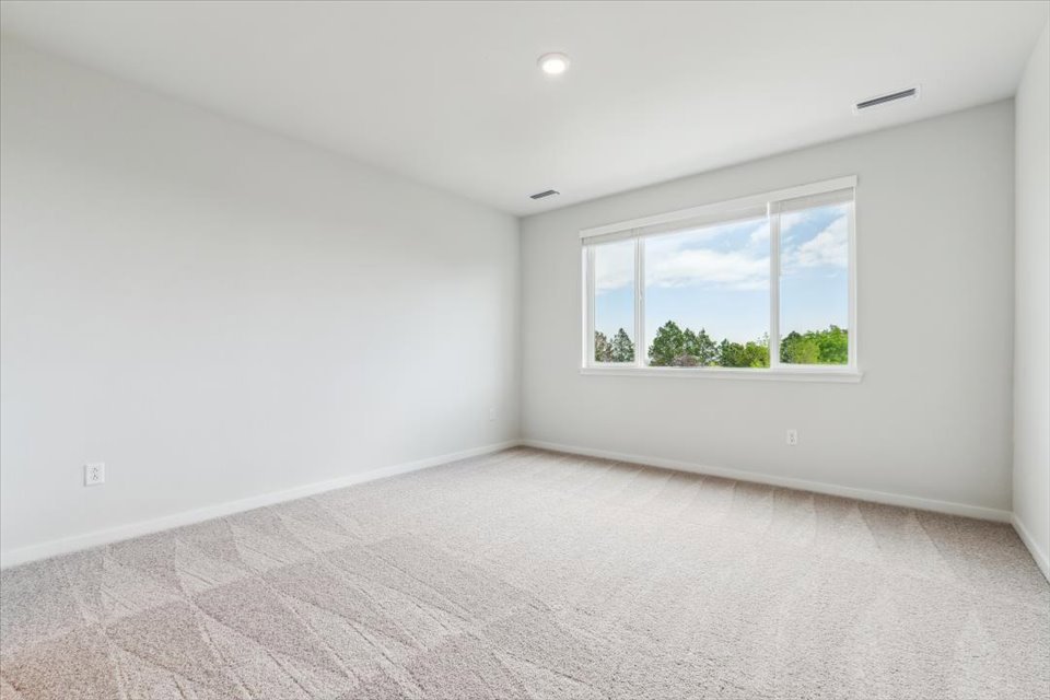 A room with a window and a rug.
