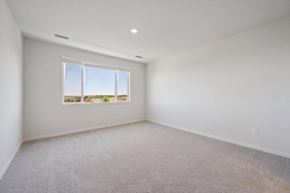 A room with a window and a carpet.