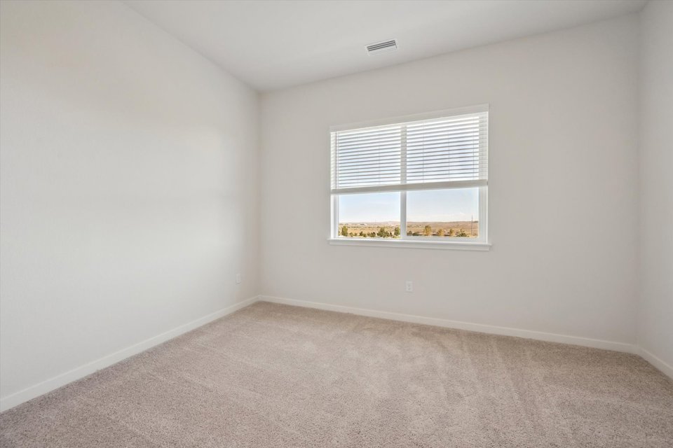 A room with a window and carpet.