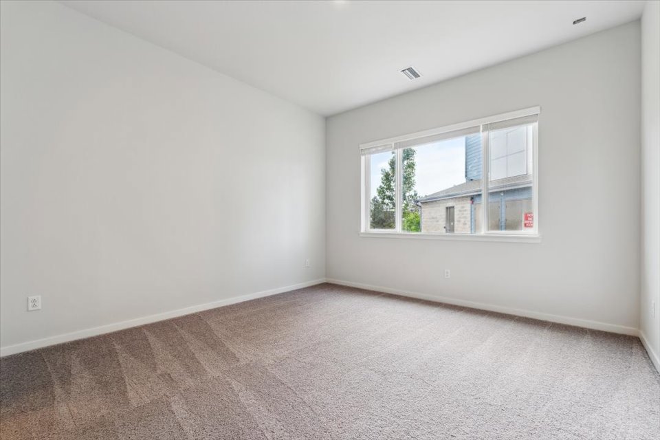 A room with a window and a carpet.